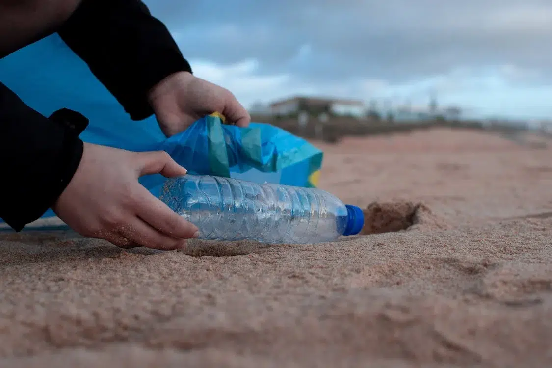 Hands picking up plastic bottles