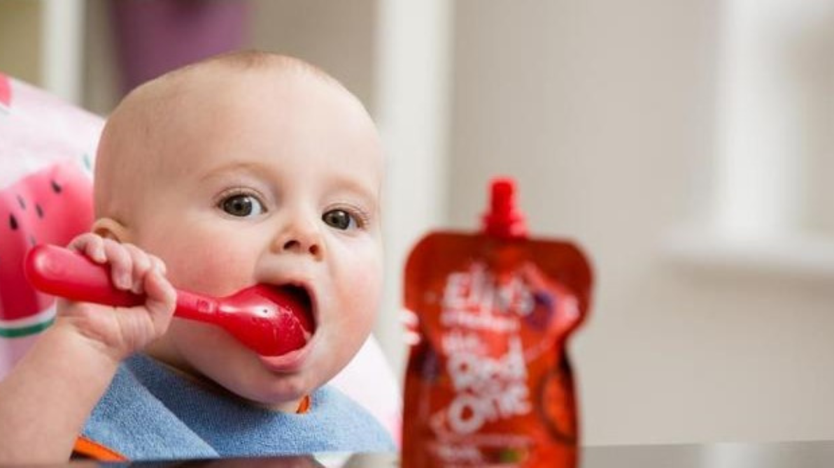 Baby eating Ella's Kitchen baby food.