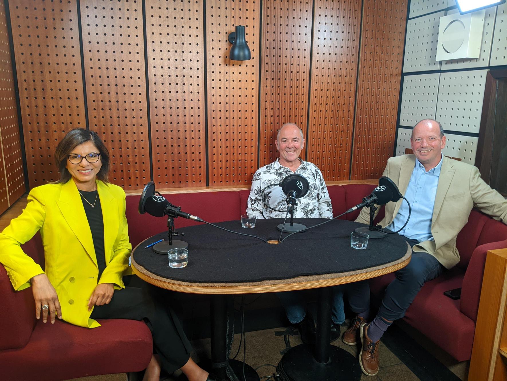 Three people from Ceuta Group sit in a podcast recording studio around a table smiling