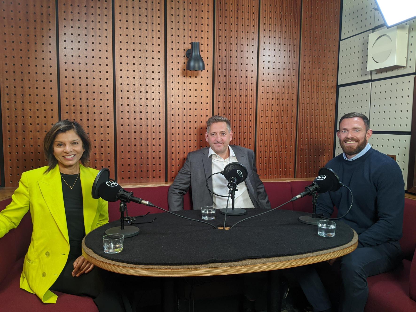 Annette D'Abreo, Chris Webster, and Andrew Smith sit in a podcast recording studio smiling